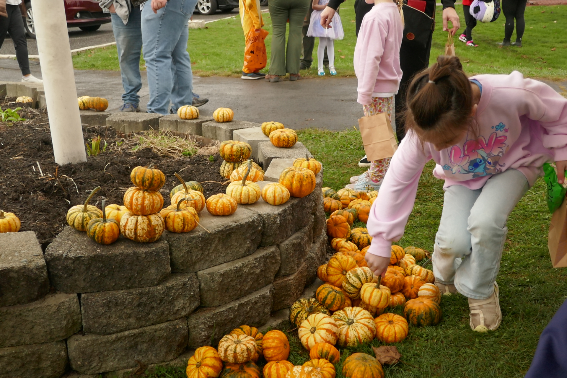 Girl picking up pumpkin